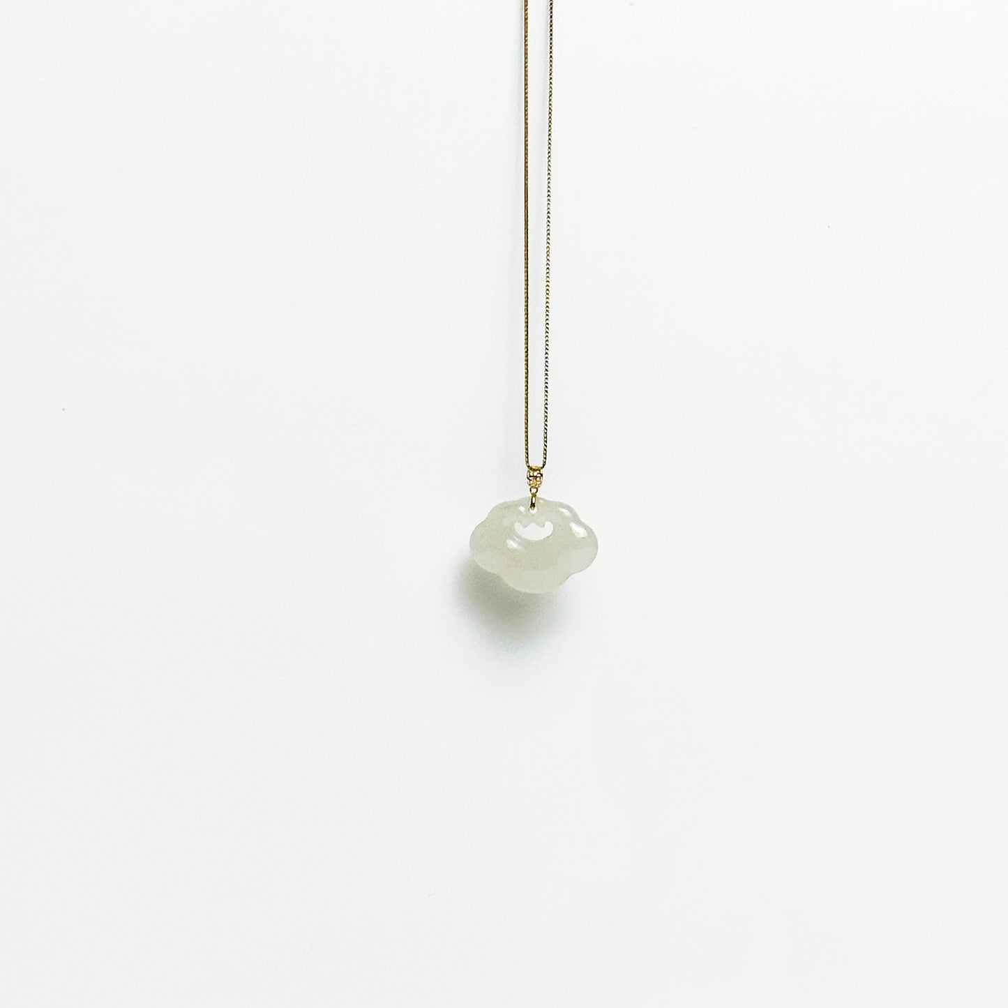 A side look of the Lucky Cloud White Jade Necklace featuring a soft white jade pendant with 18k gold bail and gold-plated 925 silver chain, in a refined minimalist design.