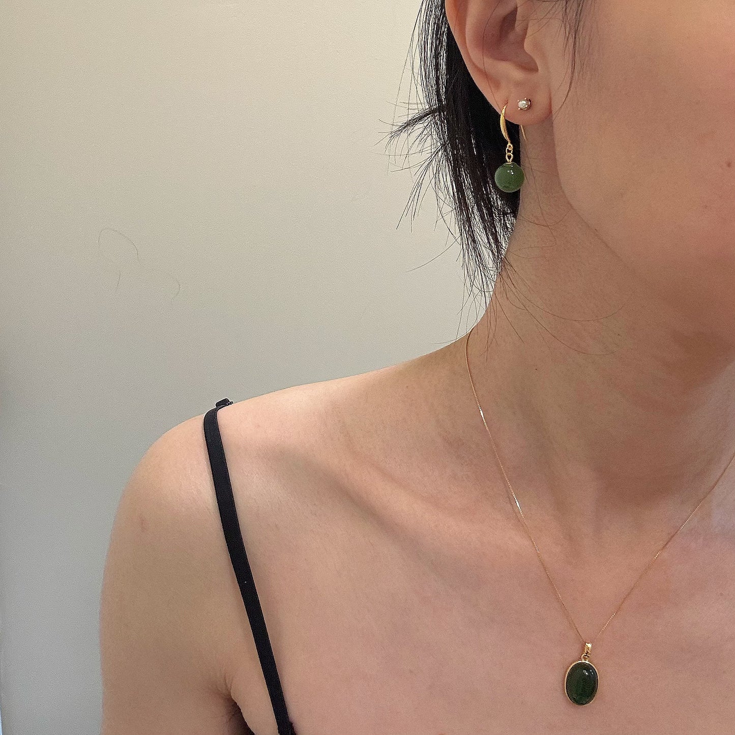 Model wearing the oval green jade pendant necklace paired with green jade drop earrings, highlighting a coordinated and elegant jade jewelry set.