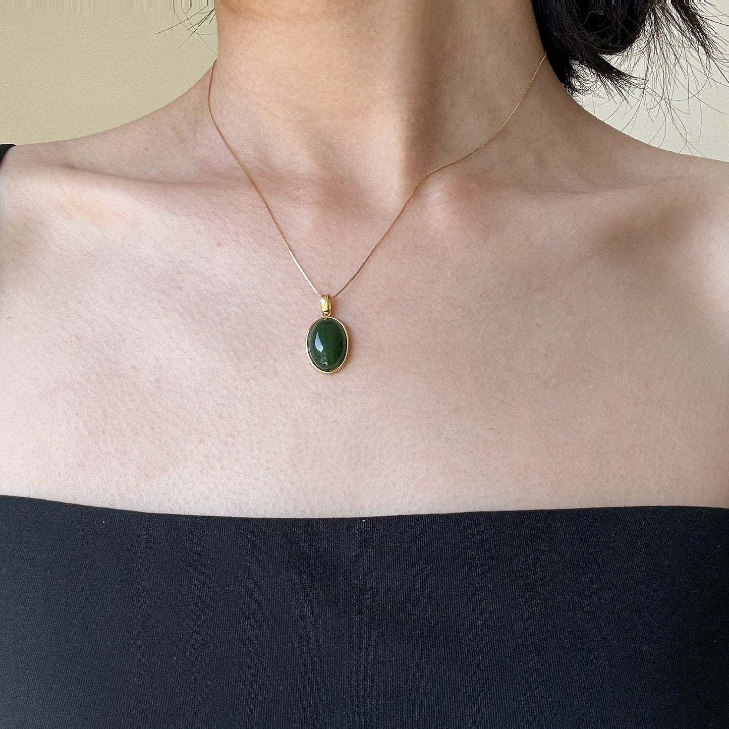 Model wearing the Oval Green Jade Necklace, showcasing its timeless elegance and classic style with a gold-plated 925 silver chain.