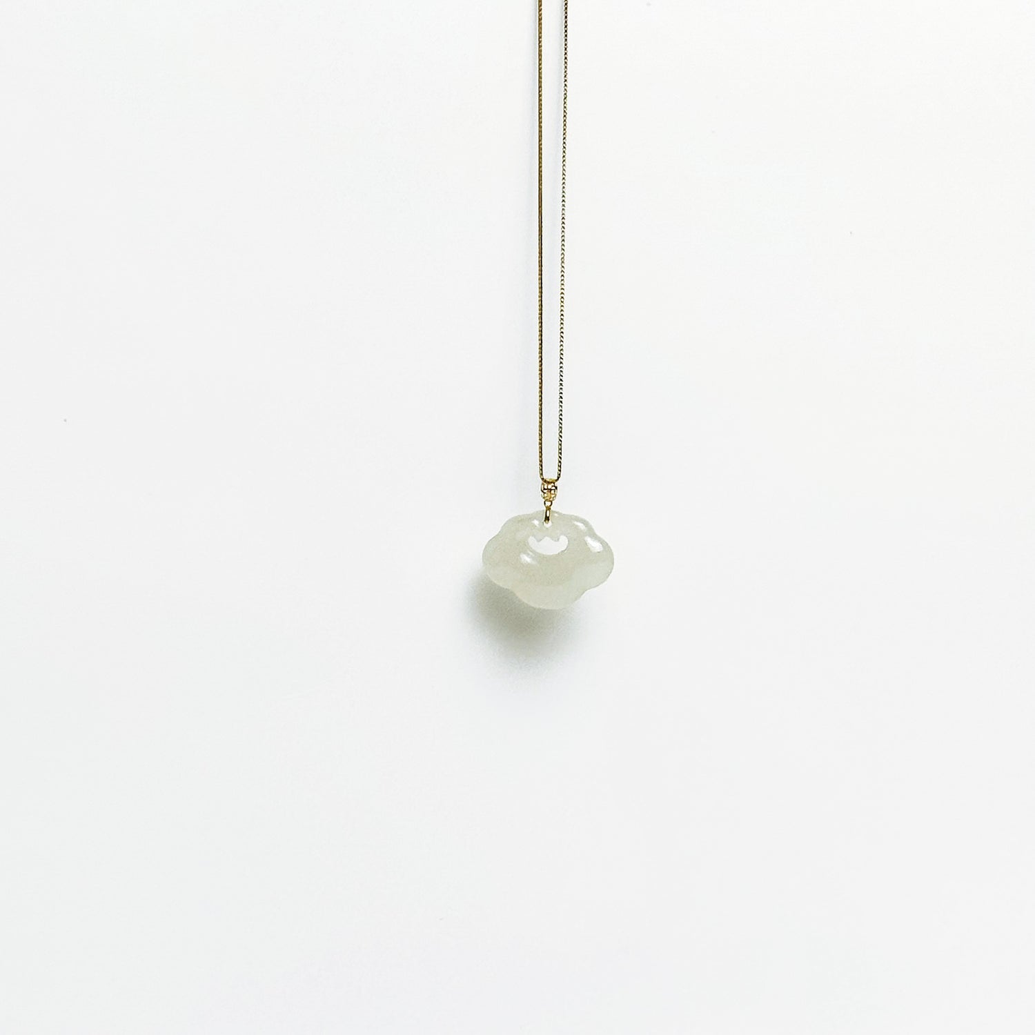 A side look of the Lucky Cloud White Jade Necklace featuring a soft white jade pendant with 18k gold bail and gold-plated 925 silver chain, in a refined minimalist design.
