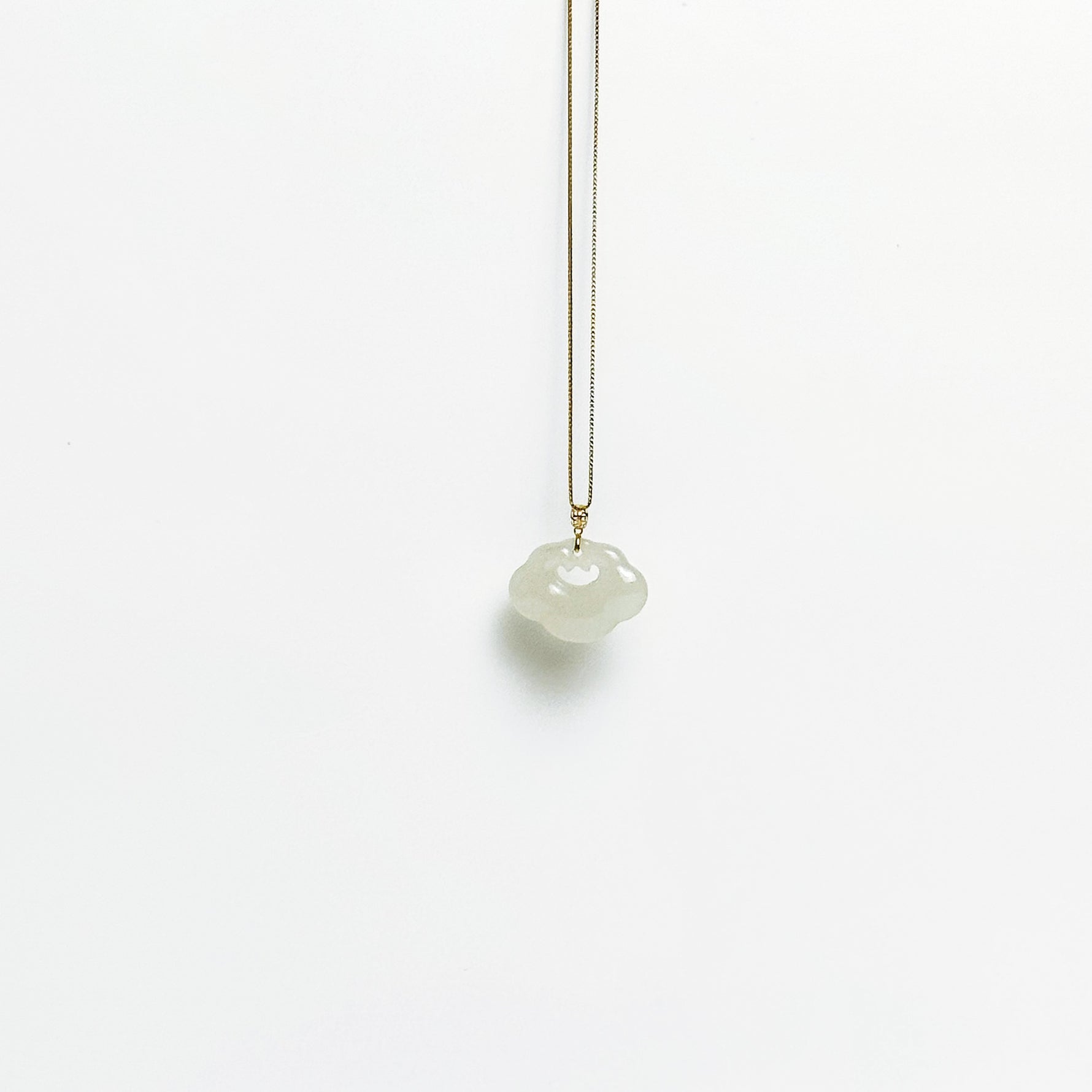 A side look of the Lucky Cloud White Jade Necklace featuring a soft white jade pendant with 18k gold bail and gold-plated 925 silver chain, in a refined minimalist design.