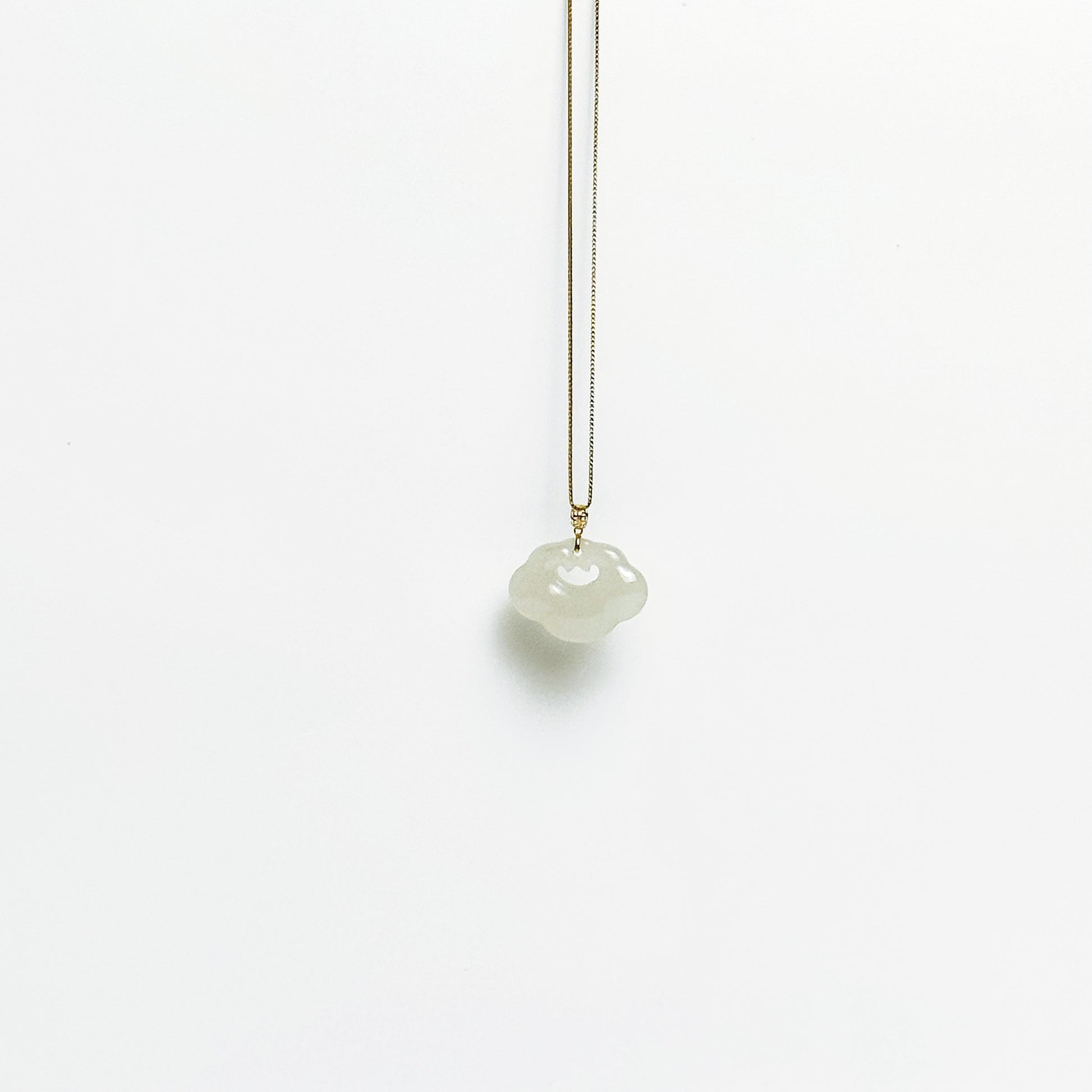 A side look of the Lucky Cloud White Jade Necklace featuring a soft white jade pendant with 18k gold bail and gold-plated 925 silver chain, in a refined minimalist design.
