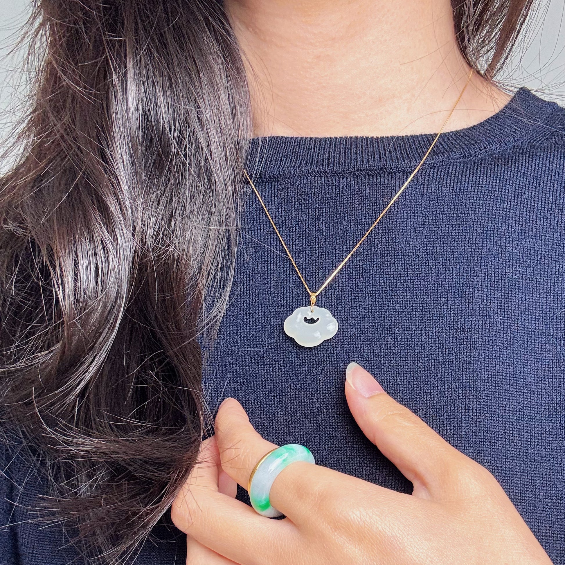 Model wearing Lucky Cloud White Jade Necklace with a navy blue top, showcasing a classic yet casual style with soft jade and gold accents.