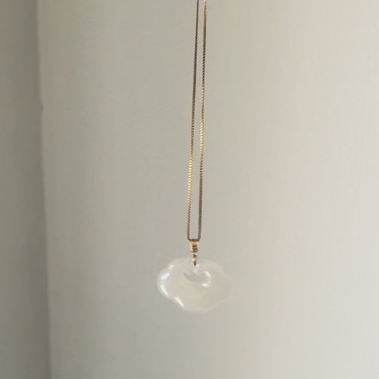 Lucky Cloud White Jade Necklace showing a soft, natural glow in sunlight, highlighting the serene beauty of white jade and gold-plated silver.